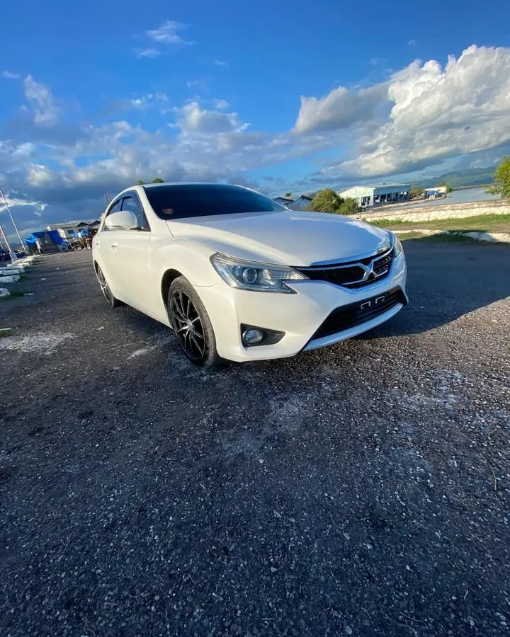 White Toyota Mark X under a blue sky
